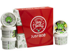 Offene Justbob XMAS KIT Box mit mehreren Behältern von legalem CBD-Blüten, mit Weihnachtsbranding und Cannabisblatt-Design, ideal für Feiertagsgeschenke